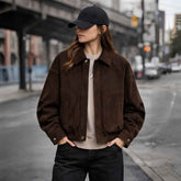 Woman wearing oversized brown suede bomber jacket with black jeans