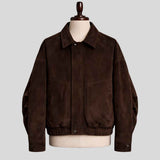 A dark brown suede utility jacket displayed on a cream-colored mannequin torso with a wooden neck cap, set against a solid light gray background.
