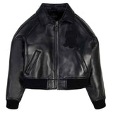 A black leather bomber jacket with a front zipper, ribbed knit collar, cuffs, and hem, featuring a tonal black embroidered patch on the left chest. The brand name 'VIVERES' is visible on the inner neck label.