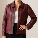Front view of women's burgundy leather jacket with point collar and centre zip, worn open over white top and black skirt