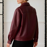 Maroon leather jacket worn by a person on a neutral background