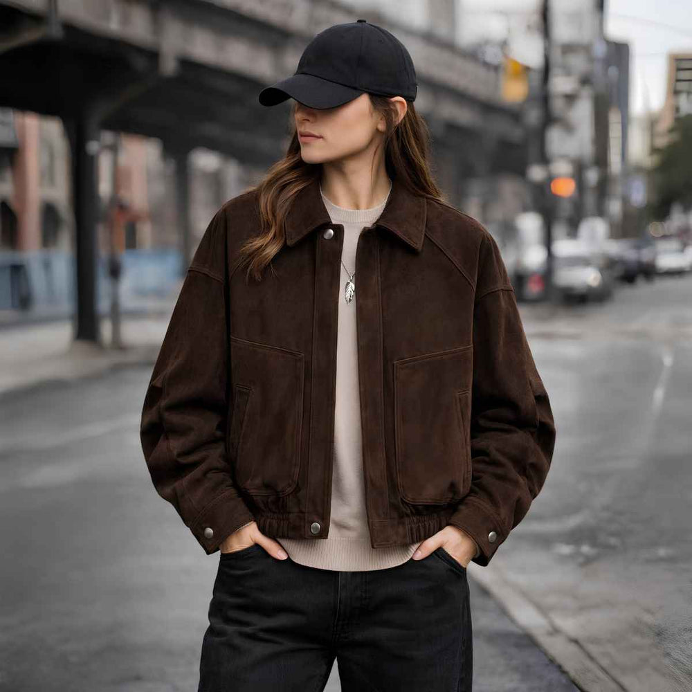 Woman wearing oversized brown suede bomber jacket with black jeans