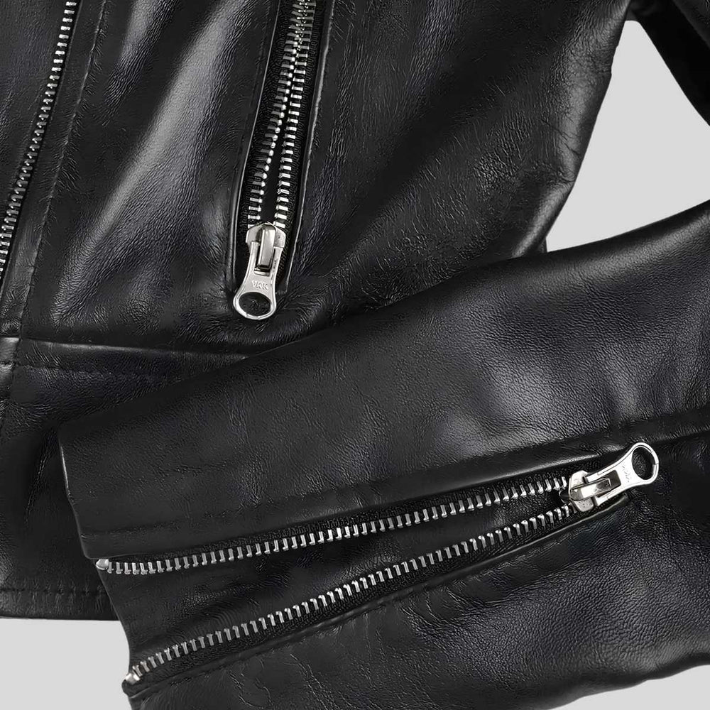 Close-up of a black leather jacket showing two silver zipper details on a light gray background.
