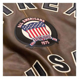 Brown leather jacket with 'All Americans' patch featuring an American flag design.