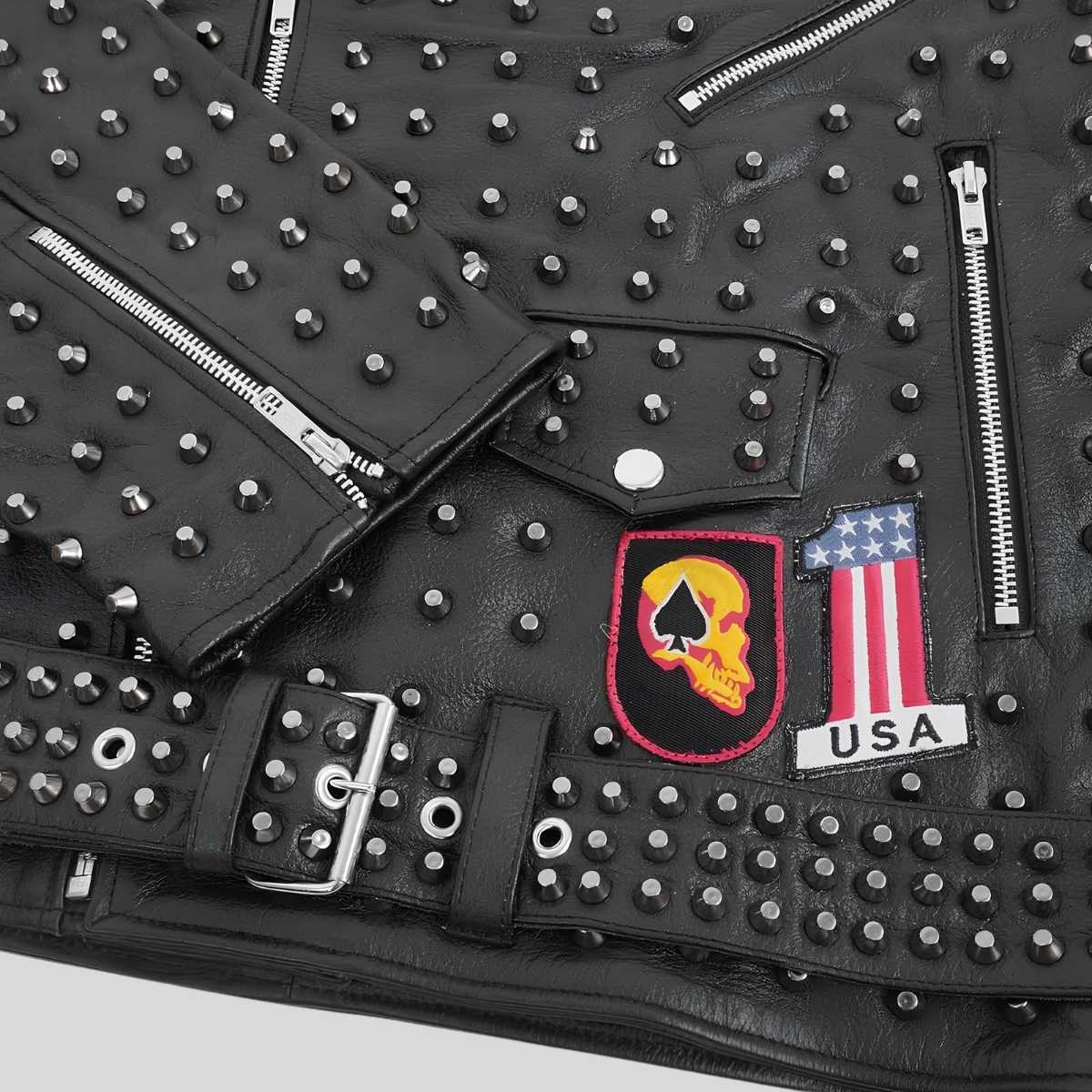 Close-up of cone spikes and patch detailing on black leather jacket