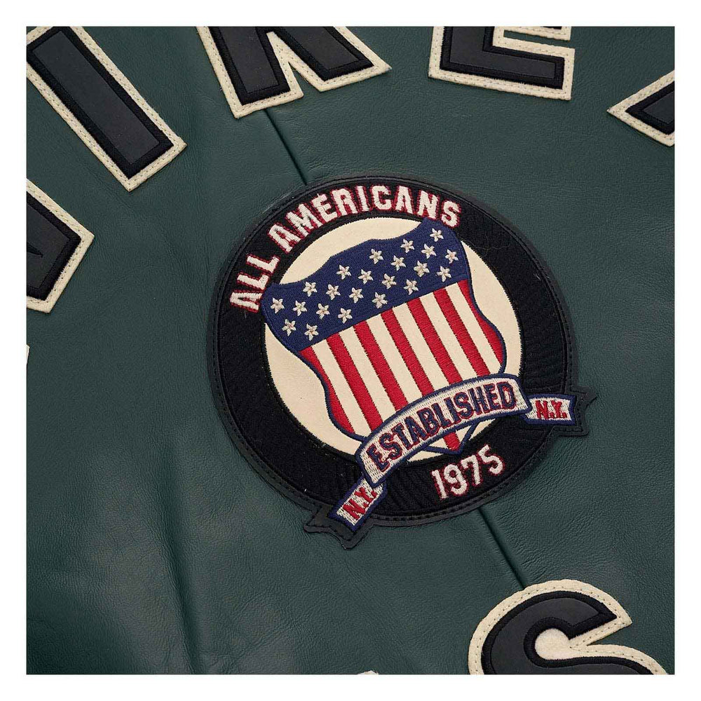 Close-up of a dark green embroidered sports jersey patch featuring an American flag design with the text 'ALL AMERICANS', 'ESTABLISHED N.Y.