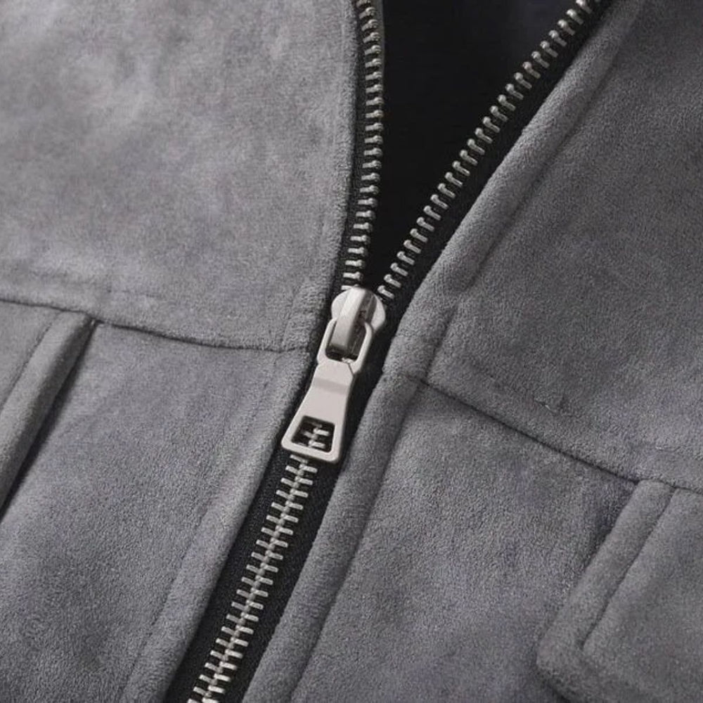 Close-up of a gray suede or micro-suede zip jacket with a silver metal zipper and pull tab.