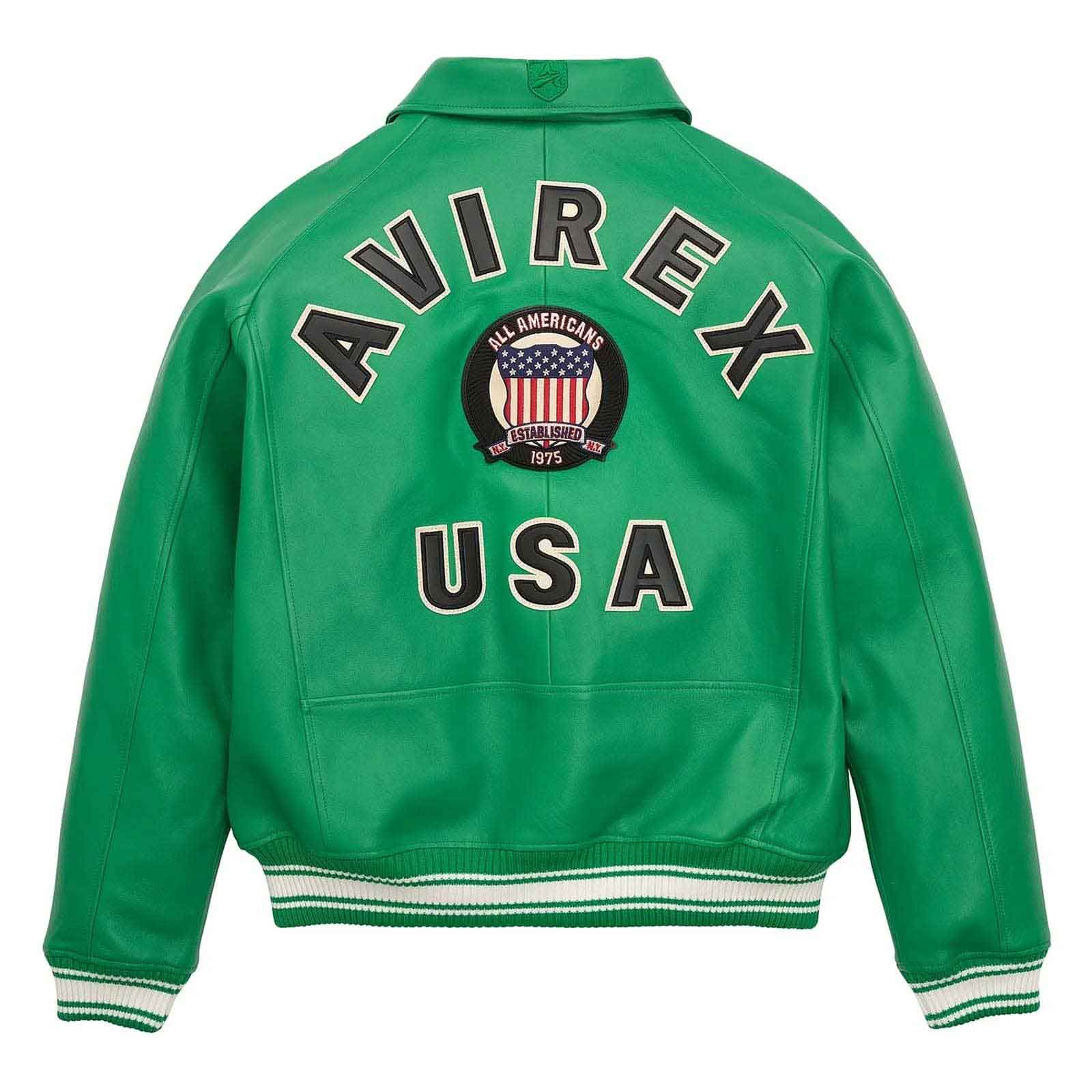 A green leather varsity jacket shown from the back, featuring 'AVIREX USA' in large black letters with white outlines, a circular American flag patch in the center, and white and black striped ribbed cuffs and hem.