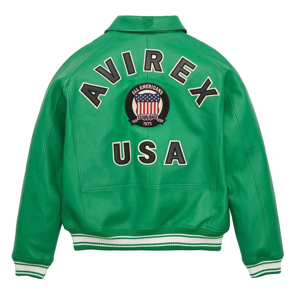 A green leather varsity jacket shown from the back, featuring 'AVIREX USA' in large black letters with white outlines, a circular American flag patch in the center, and white and black striped ribbed cuffs and hem.