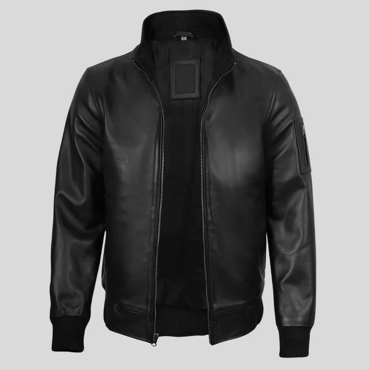A black leather bomber jacket with a stand-up collar, front zipper, ribbed cuffs and hem, and a rectangular patch on the chest, shown against a light gray background.
