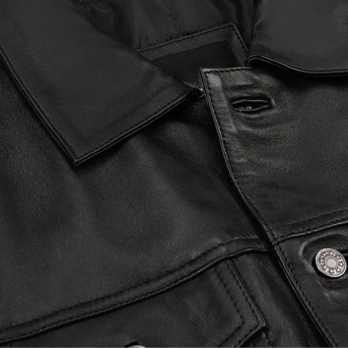 Close-up of metal buttons and chest pocket on black leather jacket