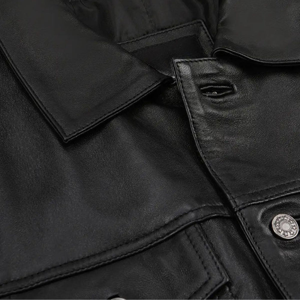 Close-up of metal buttons and chest pocket on black leather jacket