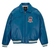 A blue leather bomber jacket with a white, red, and blue embroidered American flag patch on the left chest, featuring ribbed knit collar, cuffs, and hem with white stripes.