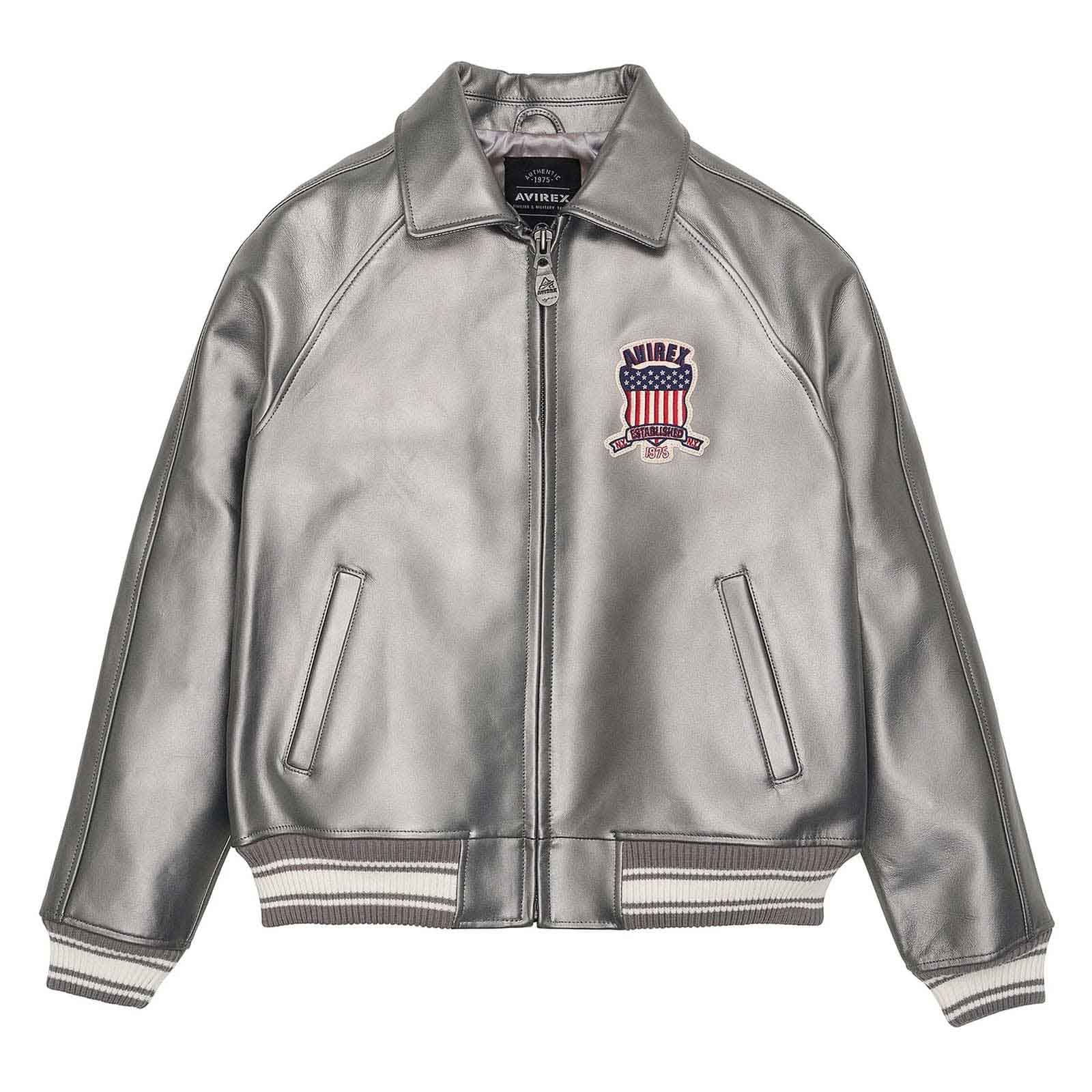 A metallic silver leather bomber jacket with a front zipper, ribbed knit collar, cuffs, and hem. It features a red, white, and blue embroidered shield patch on the left chest with the brand name 'HIMLEY'.