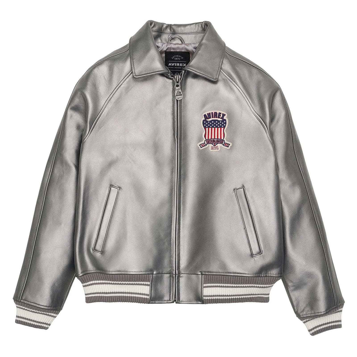 A metallic silver leather bomber jacket with a front zipper, ribbed knit collar, cuffs, and hem. It features a red, white, and blue embroidered shield patch on the left chest with the brand name 'HIMLEY'.
