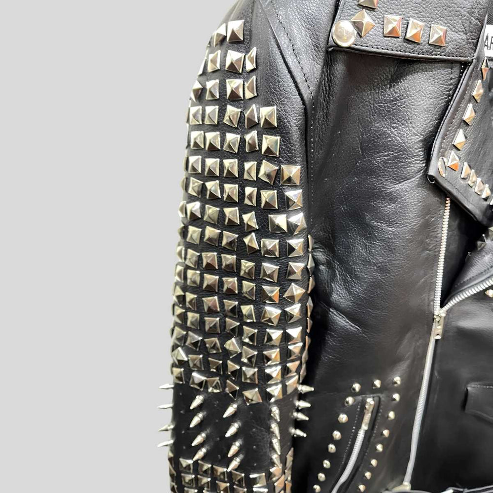 Side profile of men's black leather jacket showing belt buckle closure