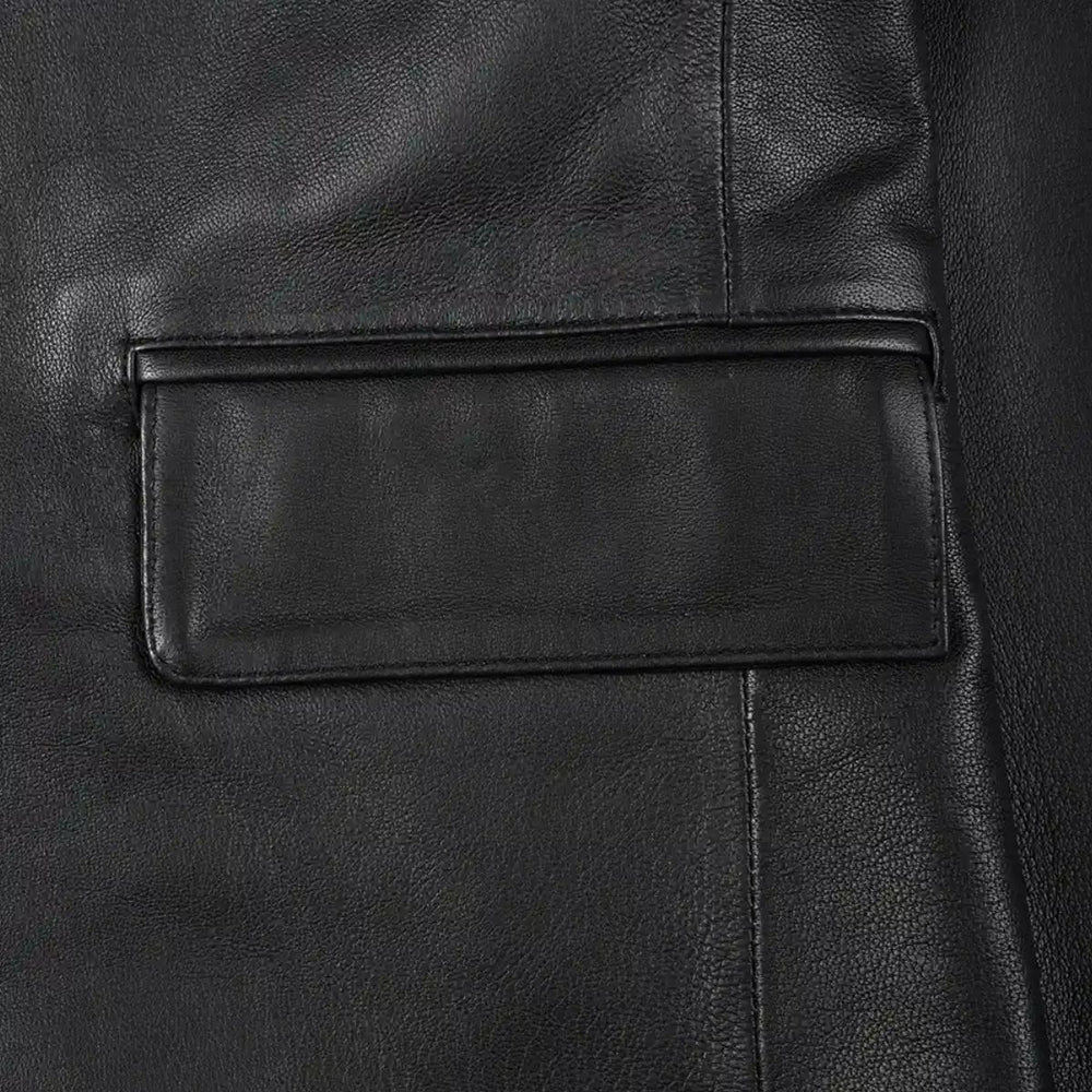 Close-up of a black leather jacket showing a rectangular flap pocket with a stitched border and pebbled leather texture.