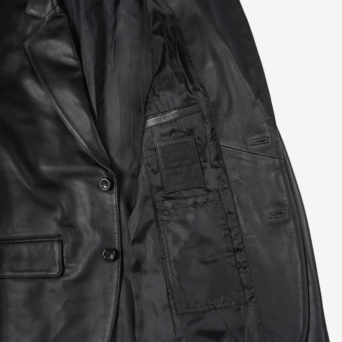 Close-up of a black leather jacket showing the interior lining, button closure, and pocket details against a light gray background.