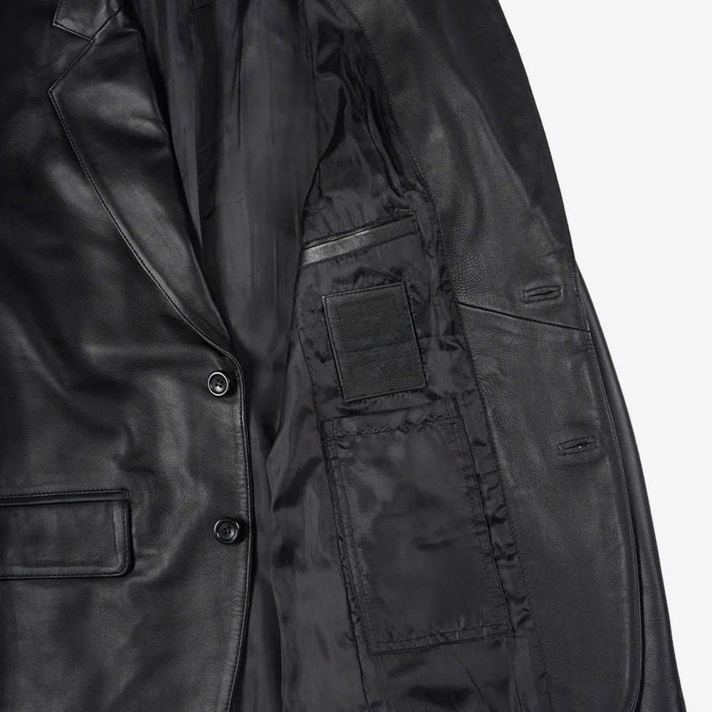 Close-up of a black leather jacket showing the interior lining, button closure, and pocket details against a light gray background.