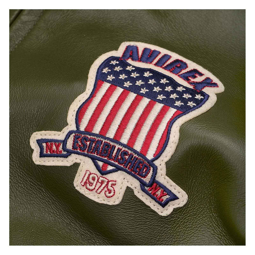 Patch with American flag design and 'Oxbow' branding on a green leather surface