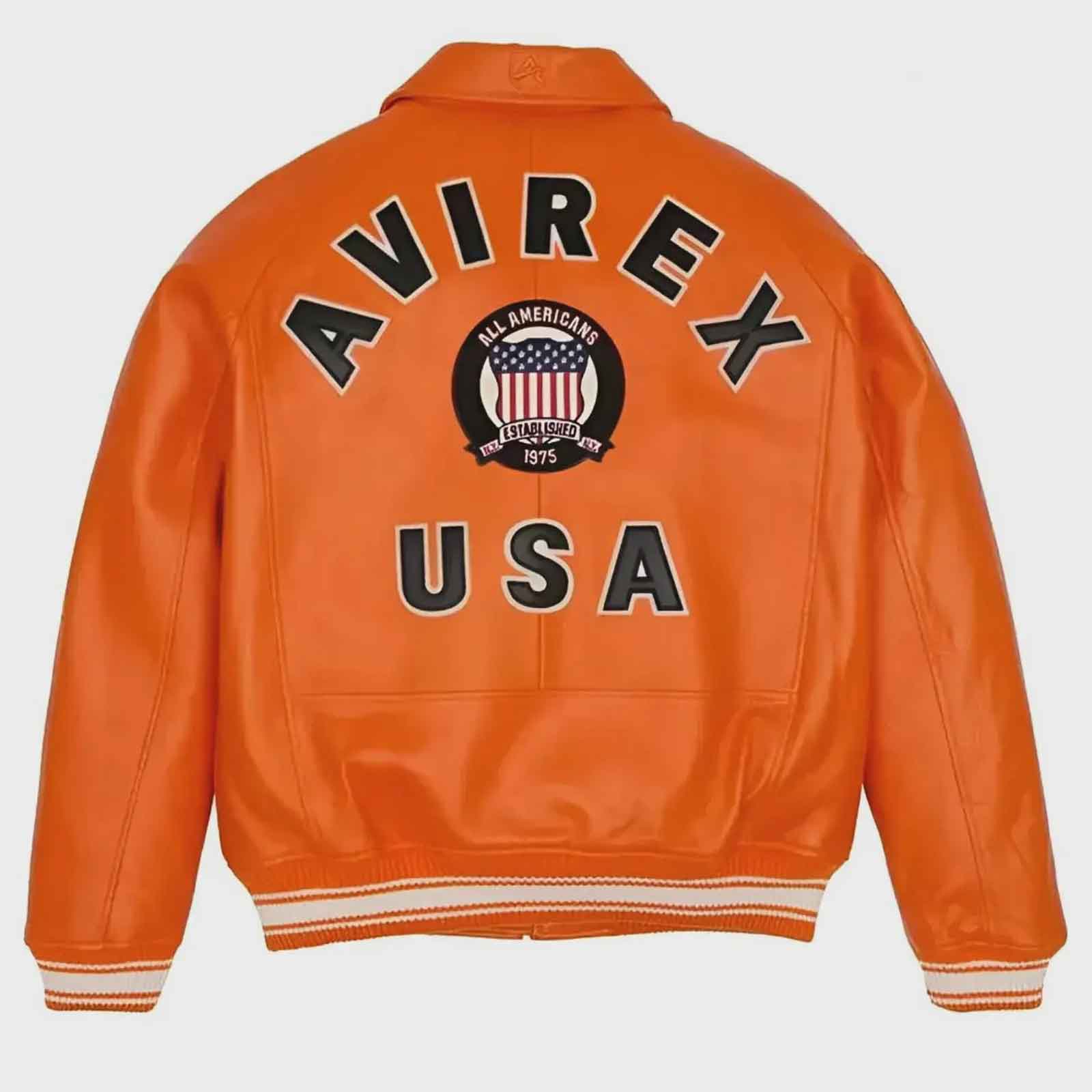 Bright orange leather jacket shown from the back, featuring large black varsity-style lettering reading 'AVIREX' with 'USA' below and a circular 'All American' crest patch in the center. The jacket has striped ribbed cuffs and hem and is photographed on a light gray background.