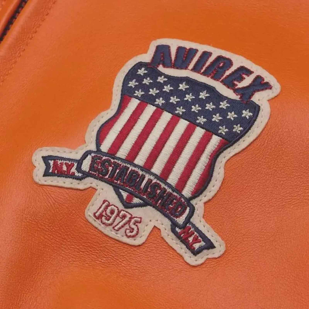 An embroidered patch featuring an American flag design with the text 'ANIREX' and 'EST. 1975 NY' on a textured orange surface.