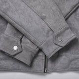 Close-up of a gray suede jacket showing the sleeve cuffs with silver snap buttons and a zipper detail at the bottom.
