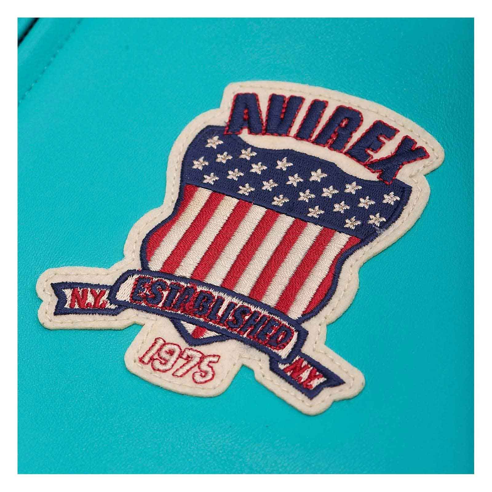 An embroidered patch featuring a shield design with red and white stripes, white stars on a blue field, and a banner reading 'N.Y.