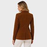 A woman shown from the back wearing a brown suede blazer and cream trousers against a light gray studio background.
