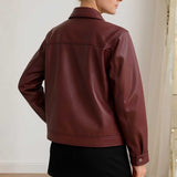 Maroon leather jacket worn by a person against a neutral background